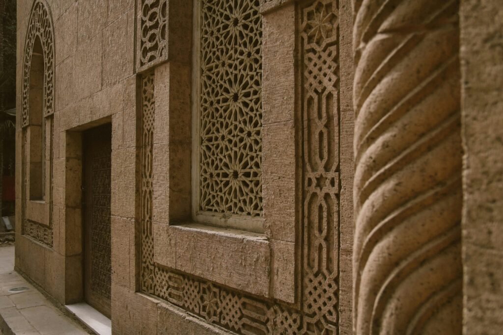 Close-up of a historic building's ornate stone facade featuring intricate geometric patterns and arches.